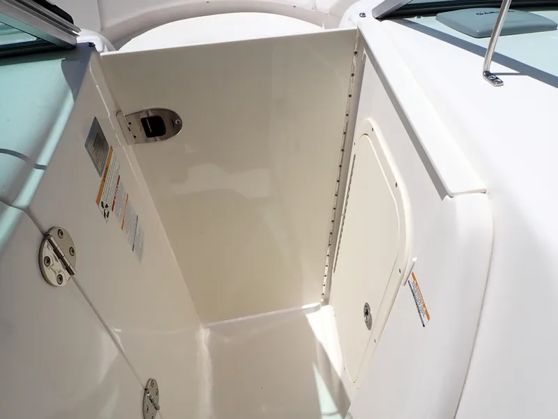 Slide: The Image of 2011 Chaparral 287 SSX boat interior compartment with white finish and metal hinges. - 20