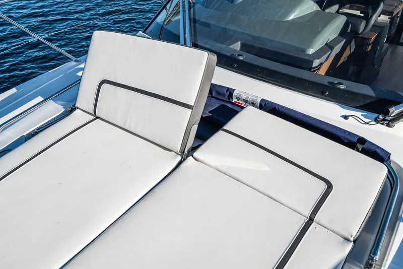Slide: The Image of 2024 Bavaria R40 yacht with white cushioned seating on deck, surrounded by water. - 20