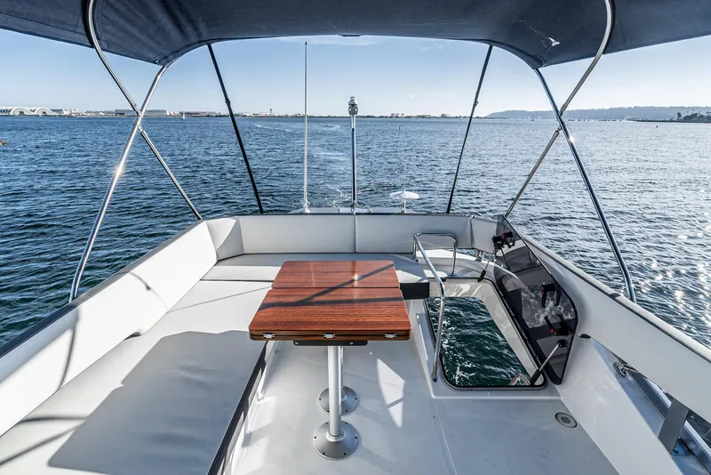 Slide: The Image of 2024 Bavaria R40 yacht deck with seating and table, overlooking calm ocean waters. - 29