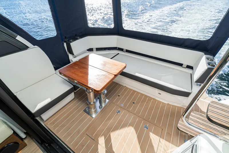 Slide: The Image of 2024 Bavaria R40 yacht interior with elegant seating and wooden table on deck. - 40