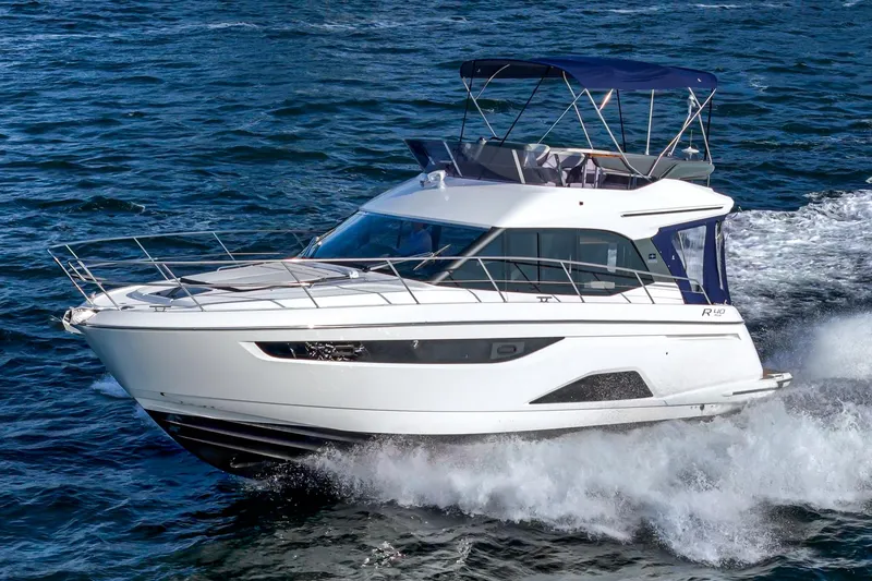 Slide: The Image of 2024 Bavaria R40 yacht cruising on open water with sleek design and blue canopy. - 7