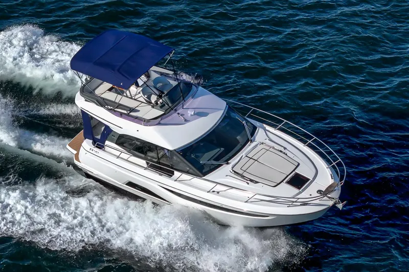Slide: The Image of 2024 Bavaria R40 yacht cruising on open water with blue canopy. - 16