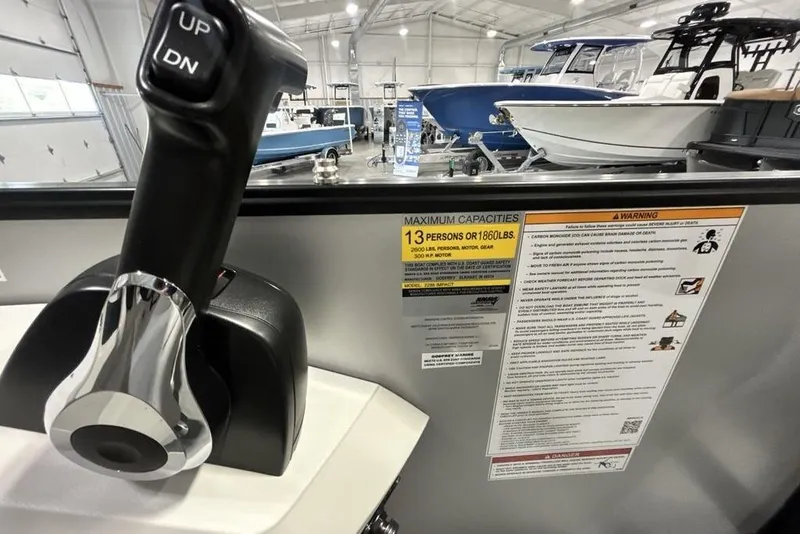 Slide: The Image of Control lever and capacity warning on 2026 Godfrey Sweetwater 2286 SFL boat in showroom. - 17