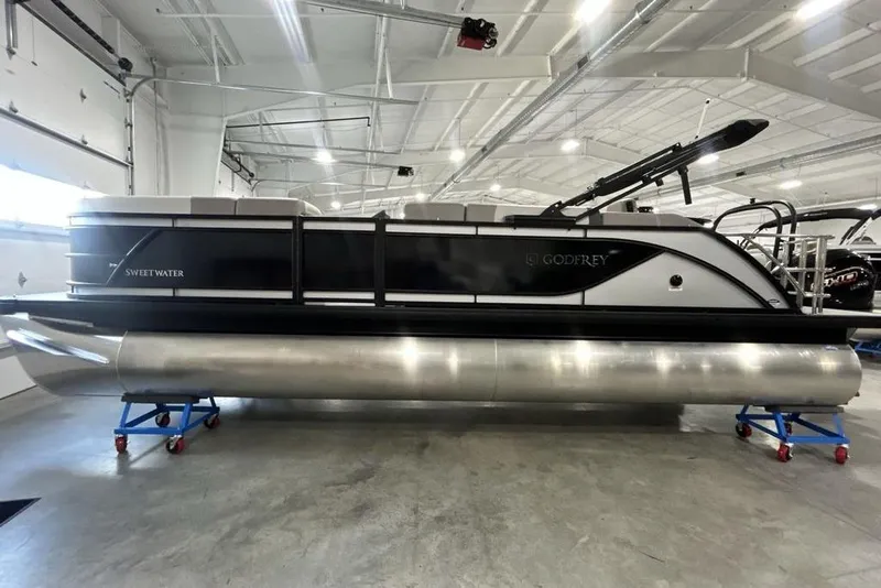 Slide: The Image of 2026 Godfrey Sweetwater 2286 SFL pontoon boat in a showroom, showcasing sleek design. - 9