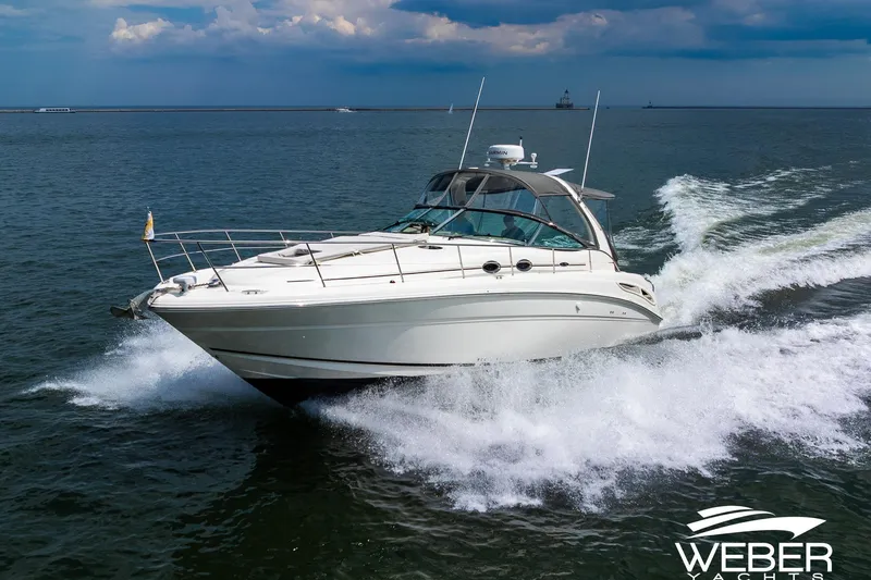 Slide: The Image of A 2005 Sea Ray 360 Sundancer speeds across the water under a cloudy sky. - 2