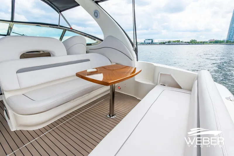 Slide: The Image of 2005 Sea Ray 360 Sundancer with stylish cockpit and wooden table. - 19