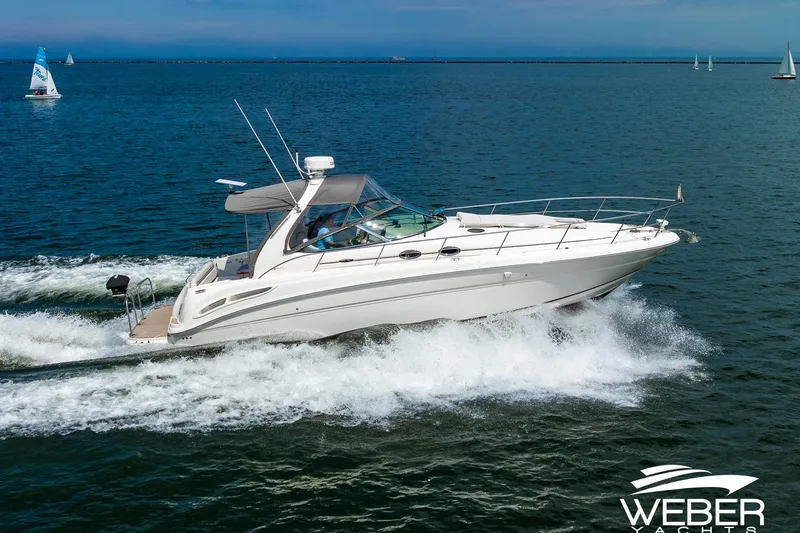 Slide: The Image of 2005 Sea Ray 360 Sundancer on the water with sailboats in the background. - 1