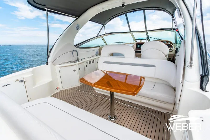 Slide: The Image of The image shows the cockpit of a 2005 Sea Ray 360 Sundancer with white seating and a wooden table. - 20