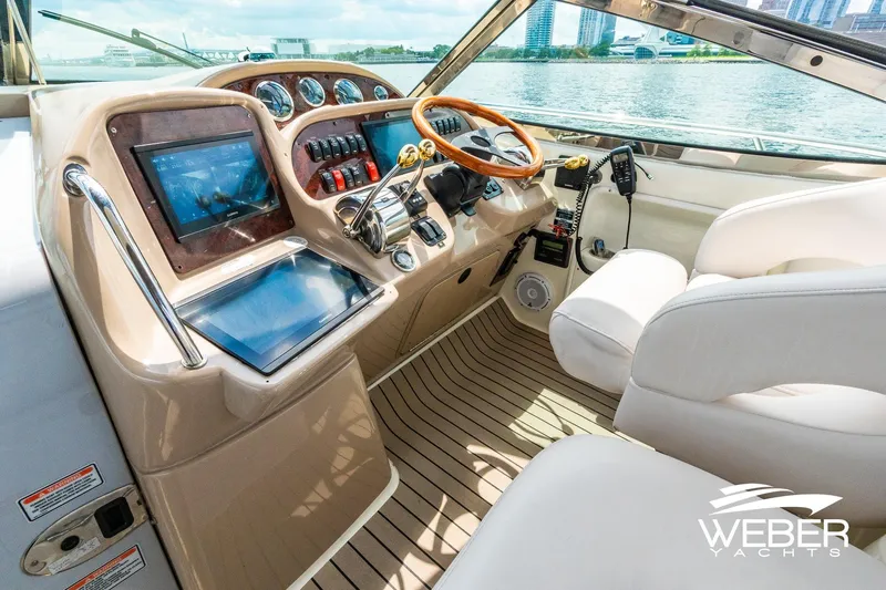 Slide: The Image of The cockpit of a 2005 Sea Ray 360 Sundancer with modern instruments and a wooden steering wheel. - 13