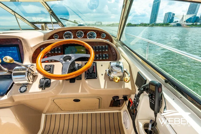 Slide: The Image of The cockpit of a 2005 Sea Ray 360 Sundancer overlooking water and city buildings. - 10