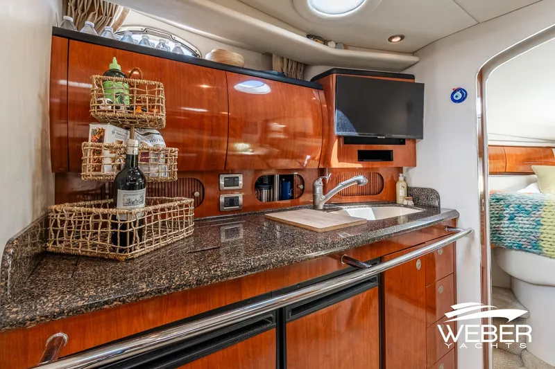 Slide: The Image of The galley of a 2005 Sea Ray 360 Sundancer with wood cabinets and granite countertop. - 25