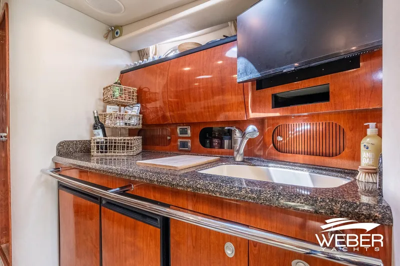 Slide: The Image of Galley area of a 2005 Sea Ray 360 Sundancer with wood paneling and sink. - 30