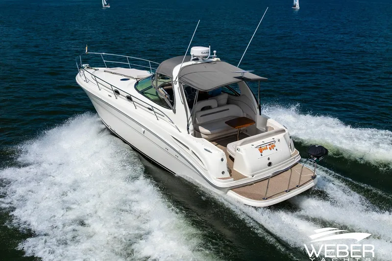 Slide: The Image of 2005 Sea Ray 360 Sundancer on the water, featuring a gray canopy and spacious deck. - 43