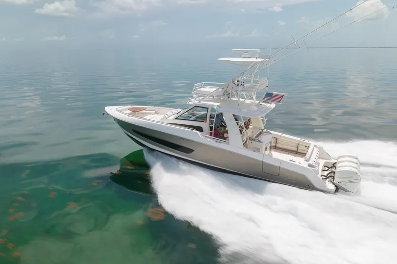 Slide: The Image of 2017 Boston Whaler 420 Outrage cruising on calm waters, showcasing sleek design and powerful engines. - 13