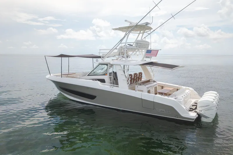 Slide: The Image of 2017 Boston Whaler 420 Outrage boat on calm water, featuring multiple outboard engines. - 7