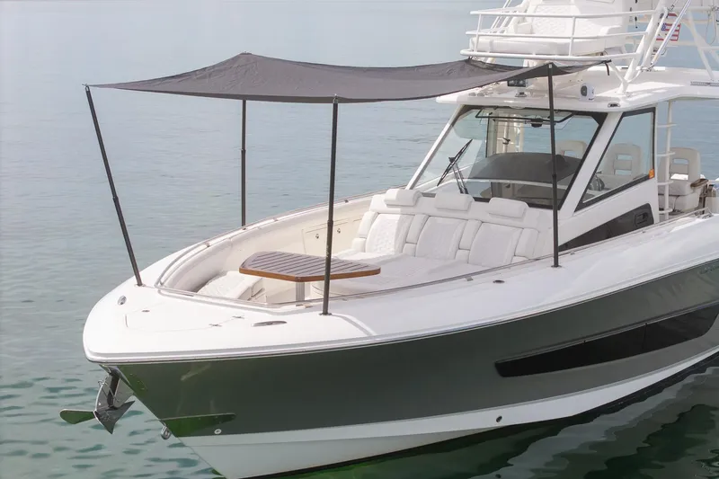 Slide: The Image of 2017 Boston Whaler 420 Outrage boat with canopy, docked on calm water. - 4
