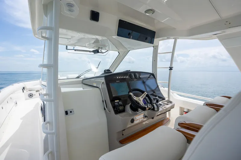 Slide: The Image of 2017 Boston Whaler 420 Outrage helm with modern controls, overlooking calm ocean waters. - 25