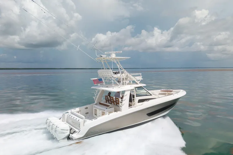 Slide: The Image of 2017 Boston Whaler 420 Outrage cruising on calm waters under cloudy skies. - 15