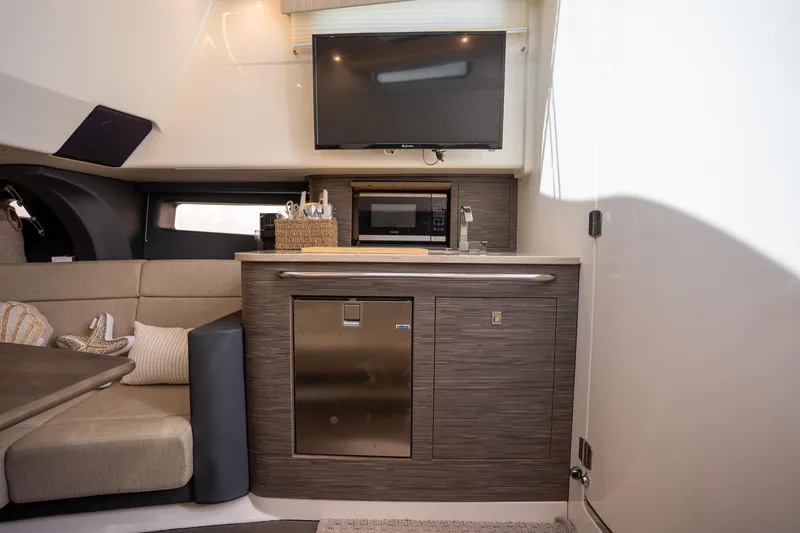 Slide: The Image of Interior of 2017 Boston Whaler 420 Outrage featuring kitchenette and seating area. - 21
