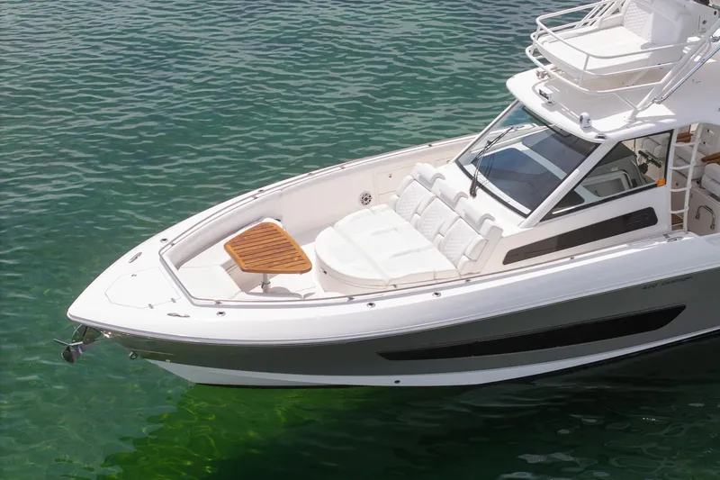 Slide: The Image of 2017 Boston Whaler 420 Outrage boat on clear water, featuring sleek design and spacious deck. - 9