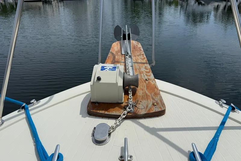 Slide: The Image of 1985 Tollycraft 34 Sundeck Motor Yacht anchor and chain on deck, docked in calm waters. - 4