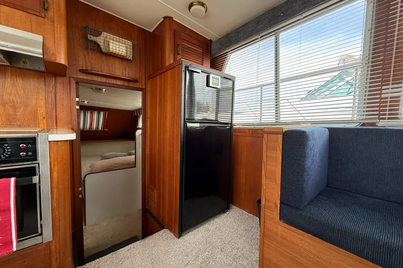 Slide: The Image of 1985 Tollycraft 34 Sundeck Motor Yacht interior with wood paneling and modern appliances. - 25