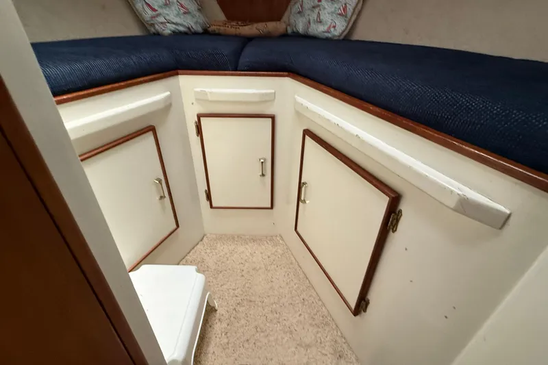 Slide: The Image of 1985 Tollycraft 34 Sundeck Motor Yacht interior with storage cabinets and cushioned seating. - 38
