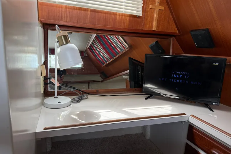 Slide: The Image of 1985 Tollycraft 34 Sundeck Motor Yacht interior with desk, lamp, and TV. - 36