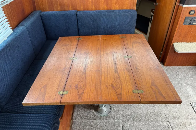 Slide: The Image of Interior of 1985 Tollycraft 34 Sundeck Motor Yacht with wooden table and blue seating. - 28