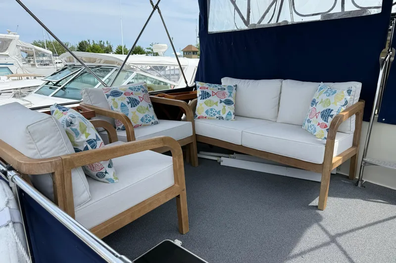 Slide: The Image of 1985 Tollycraft 34 Sundeck Motor Yacht interior with cushioned seating and colorful pillows. - 8