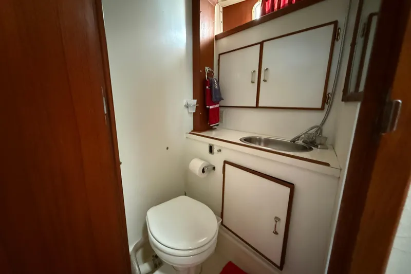 Slide: The Image of 1985 Tollycraft 34 Sundeck Motor Yacht bathroom with sink, toilet, and storage cabinets. - 39
