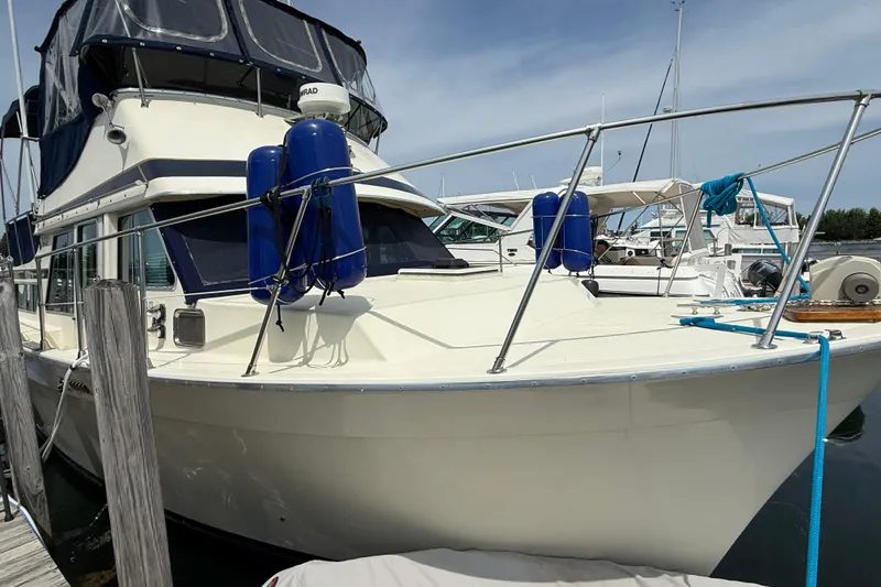 Slide: The Image of 1985 Tollycraft 34 Sundeck Motor Yacht docked with blue fenders and canopy. - 3