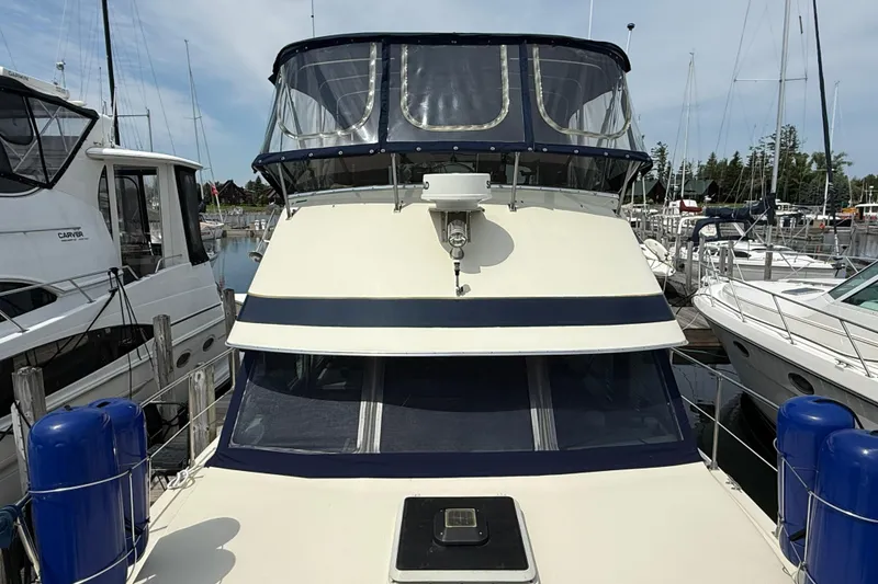 Slide: The Image of 1985 Tollycraft 34 Sundeck Motor Yacht docked at marina, front view. - 5