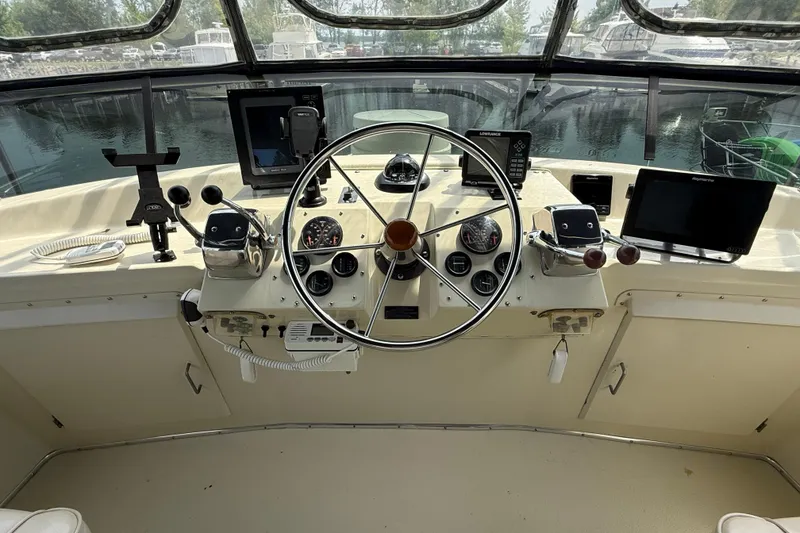 Slide: The Image of 1985 Tollycraft 34 Sundeck Motor Yacht helm with steering wheel and navigation instruments. - 10