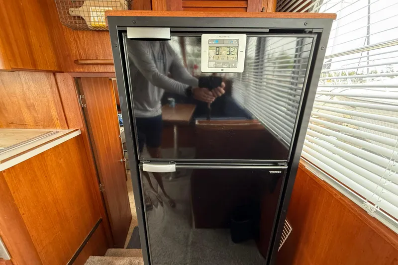 Slide: The Image of Interior of 1985 Tollycraft 34 Sundeck Motor Yacht with refrigerator and wooden cabinetry. - 26