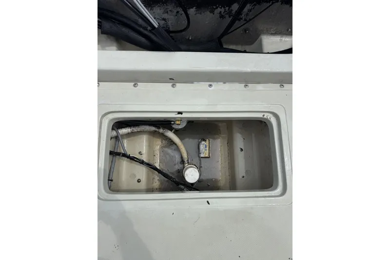 Slide: The Image of 1983 Boston Whaler 21 Outrage boat compartment with visible wiring and hoses. - 14