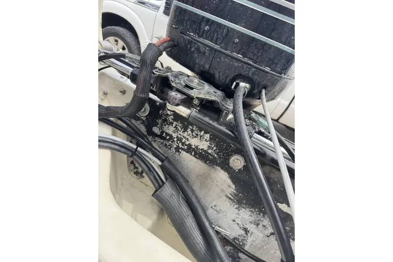 Slide: The Image of Close-up of a 1983 Boston Whaler 21 Outrage boat engine with visible cables and wear. - 13