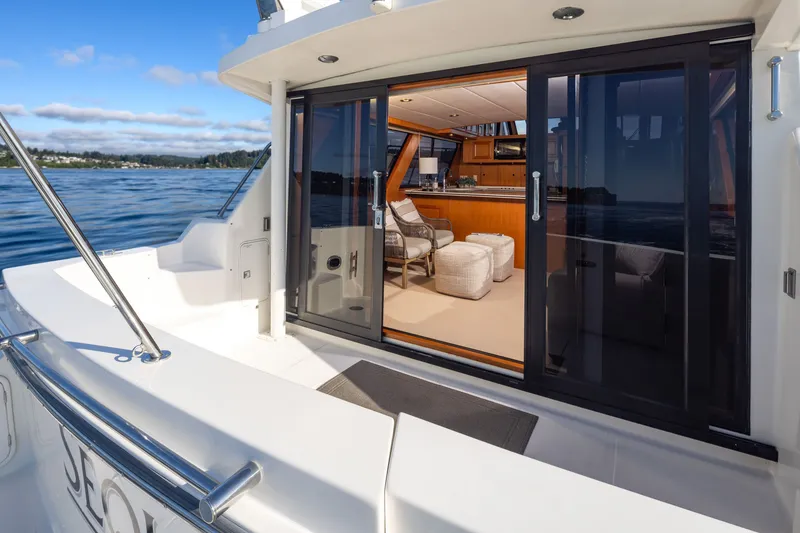 Slide: The Image of Luxurious 2000 Symbol 50 Pilothouse yacht interior with sliding glass doors and scenic ocean view. - 1