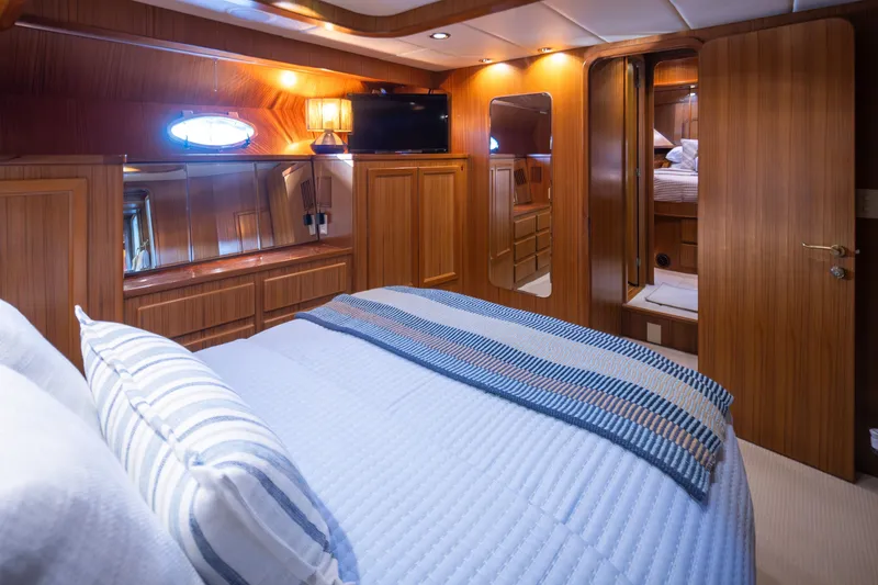 Slide: The Image of Luxurious cabin interior of a 2000 Symbol 50 Pilothouse yacht with wood paneling and cozy bedding. - 12