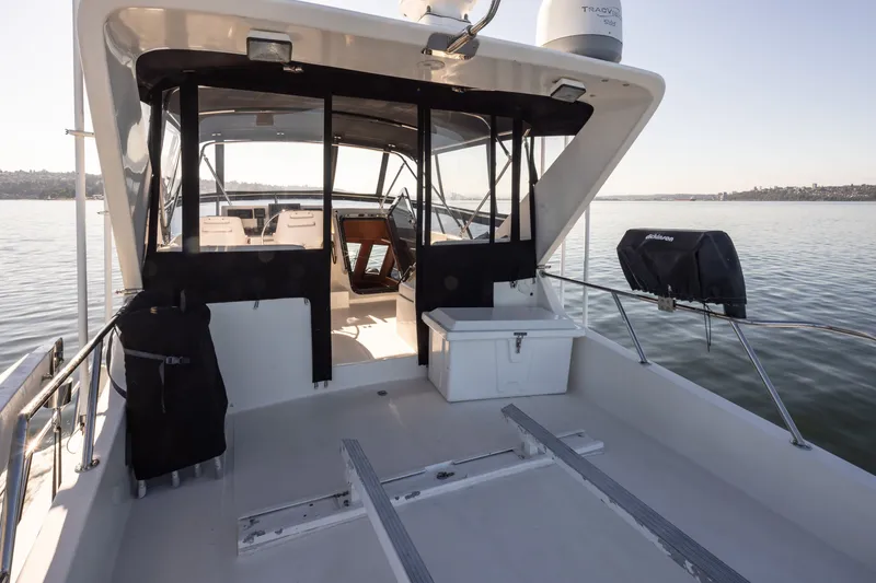 Slide: The Image of 2000 Symbol 50 Pilothouse boat interior with seating, docked on calm water. - 21