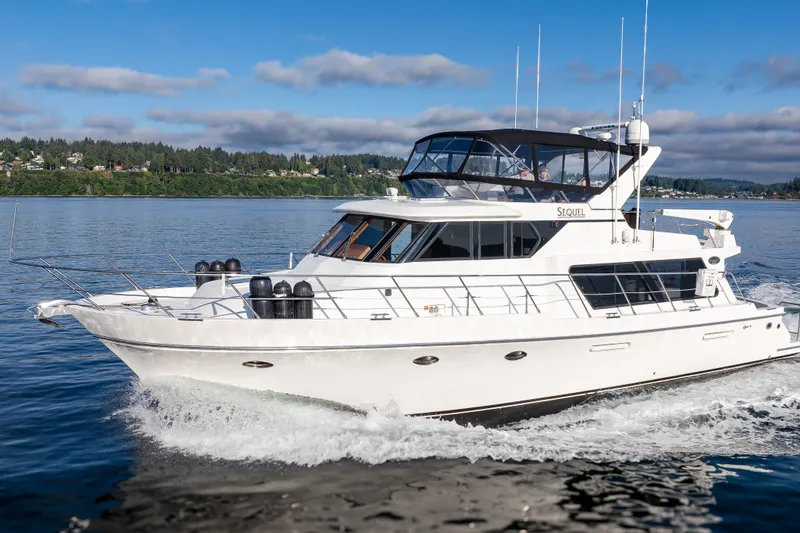 Slide: The Image of Luxury Symbol 50 Pilothouse yacht cruising on a serene lake, 2000 model. - 28