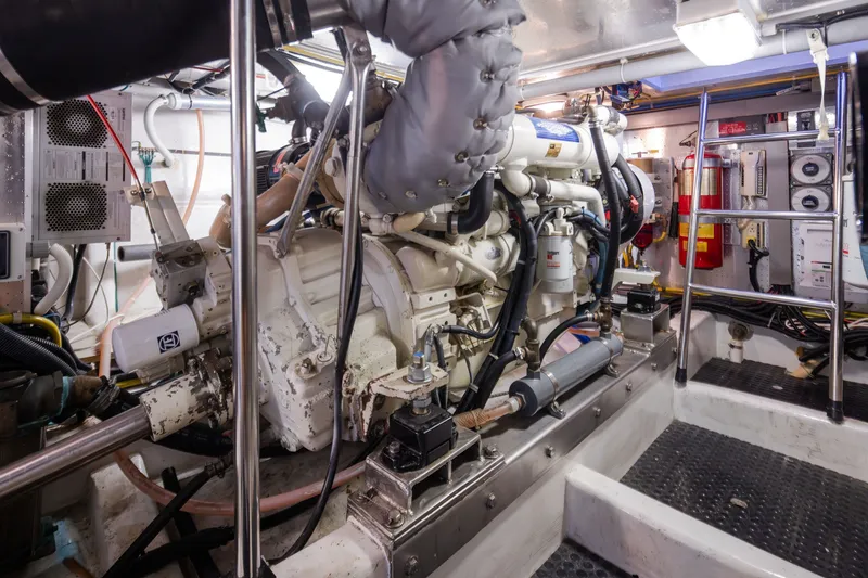 Slide: The Image of Engine room of a 2000 Symbol 50 Pilothouse yacht, featuring complex machinery and equipment. - 23