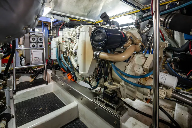Slide: The Image of Engine room of a 2000 Symbol 50 Pilothouse yacht, showcasing complex machinery and wiring. - 24