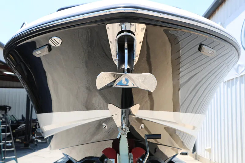 Slide: The Image of 2026 Chaparral 30 Surf boat, sleek black hull, docked in a marina. - 17