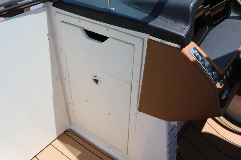 Slide: The Image of 2026 Chaparral 30 Surf boat interior with control panel and storage compartment. - 51