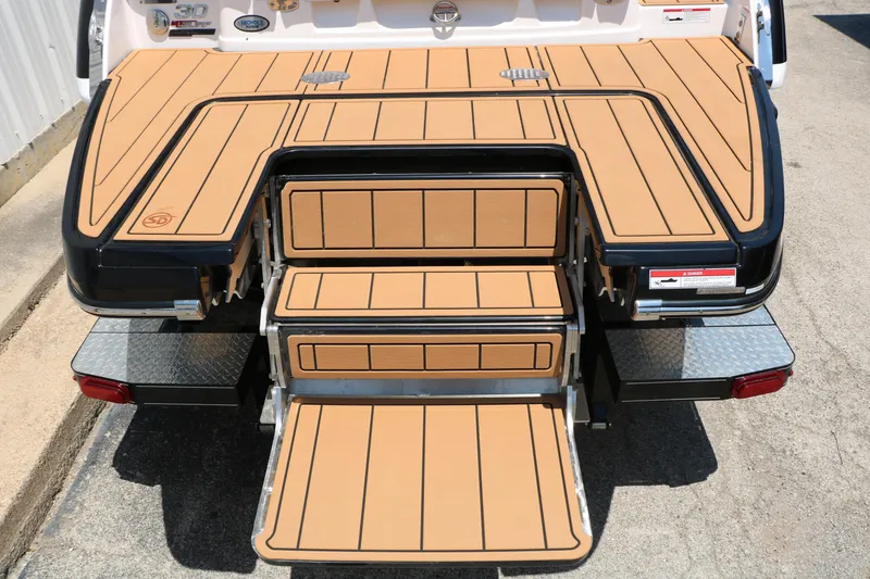 Slide: The Image of 2026 Chaparral 30 Surf boat with tan deck and foldable swim platform. - 21