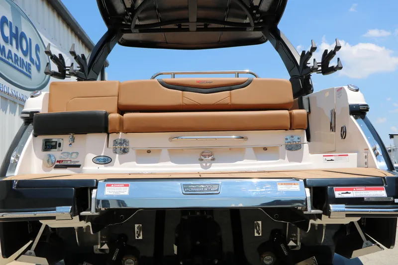 Slide: The Image of 2026 Chaparral 30 Surf boat rear view with tan seating and marine equipment. - 14