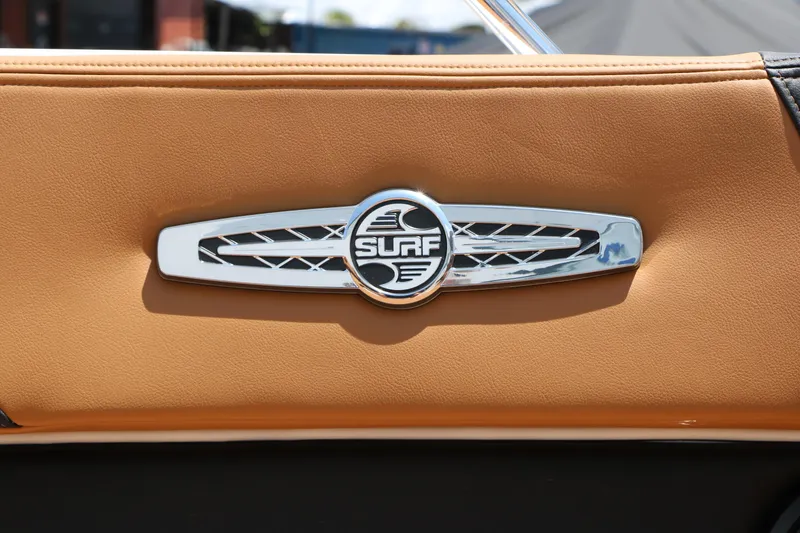 Slide: The Image of 2026 Chaparral 30 Surf interior detail with chrome emblem on tan leather. - 54