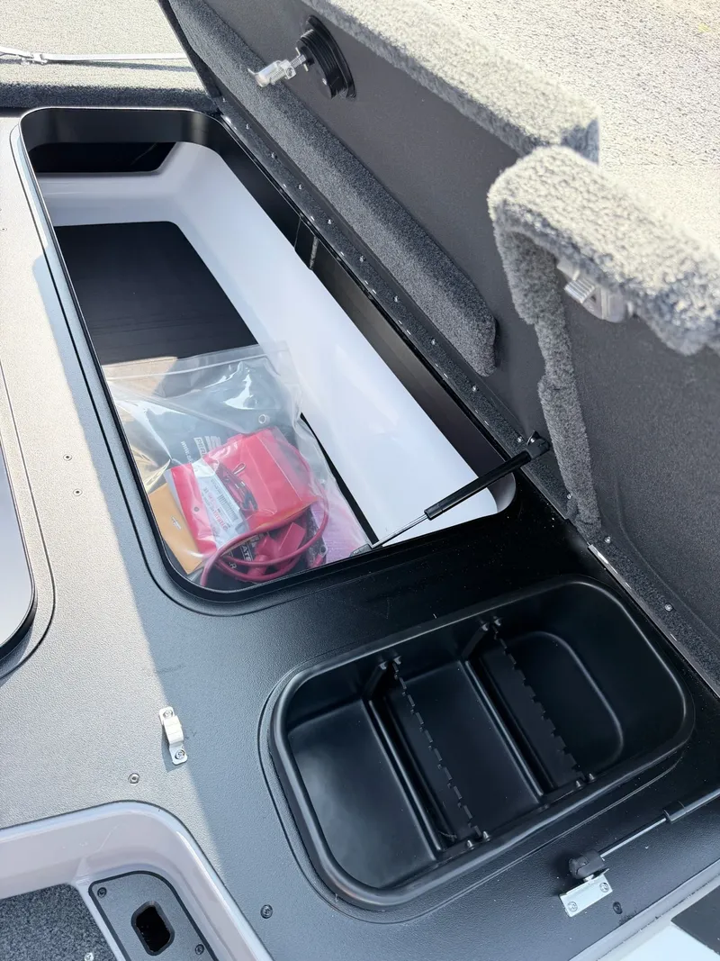 Slide: The Image of An open storage compartment on a boat with a bag and accessories. - 28