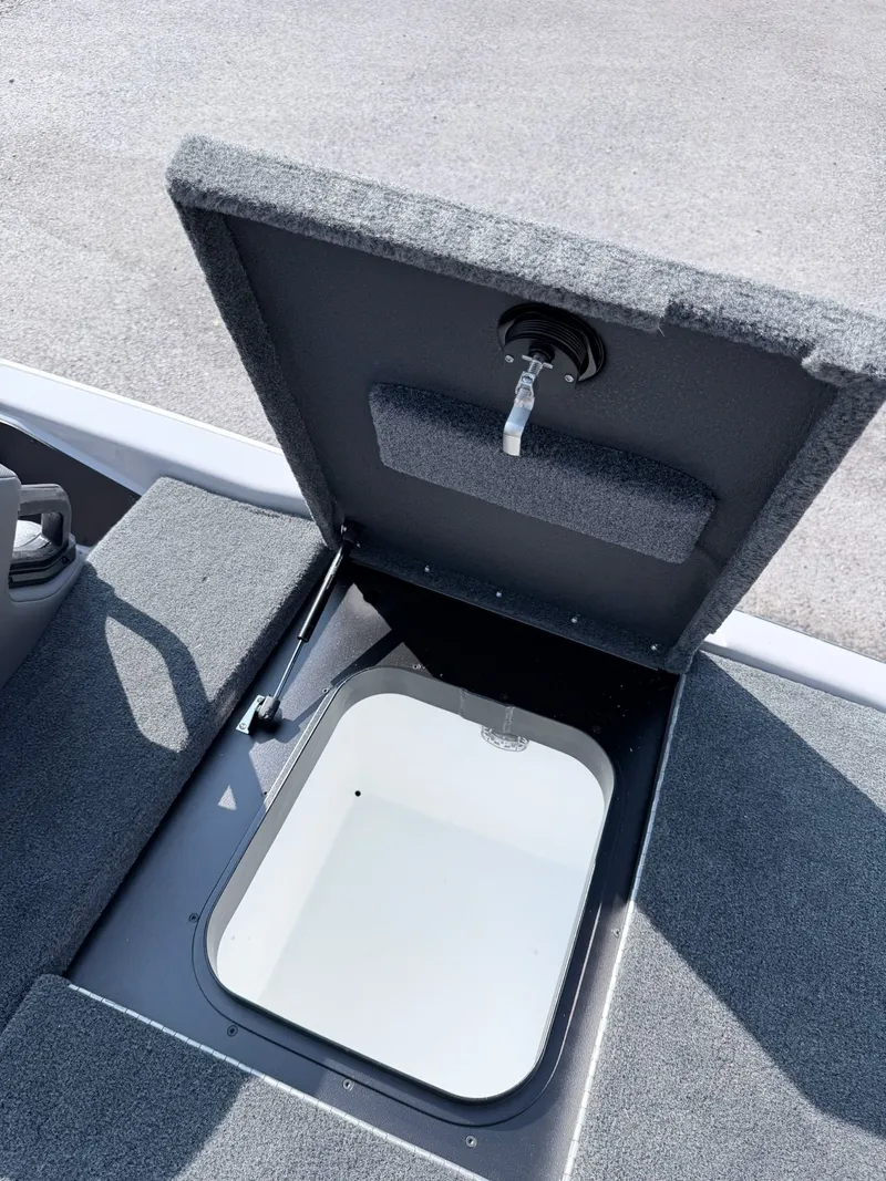 Slide: The Image of Open storage hatch on a boat with gray carpeted flooring. - 16